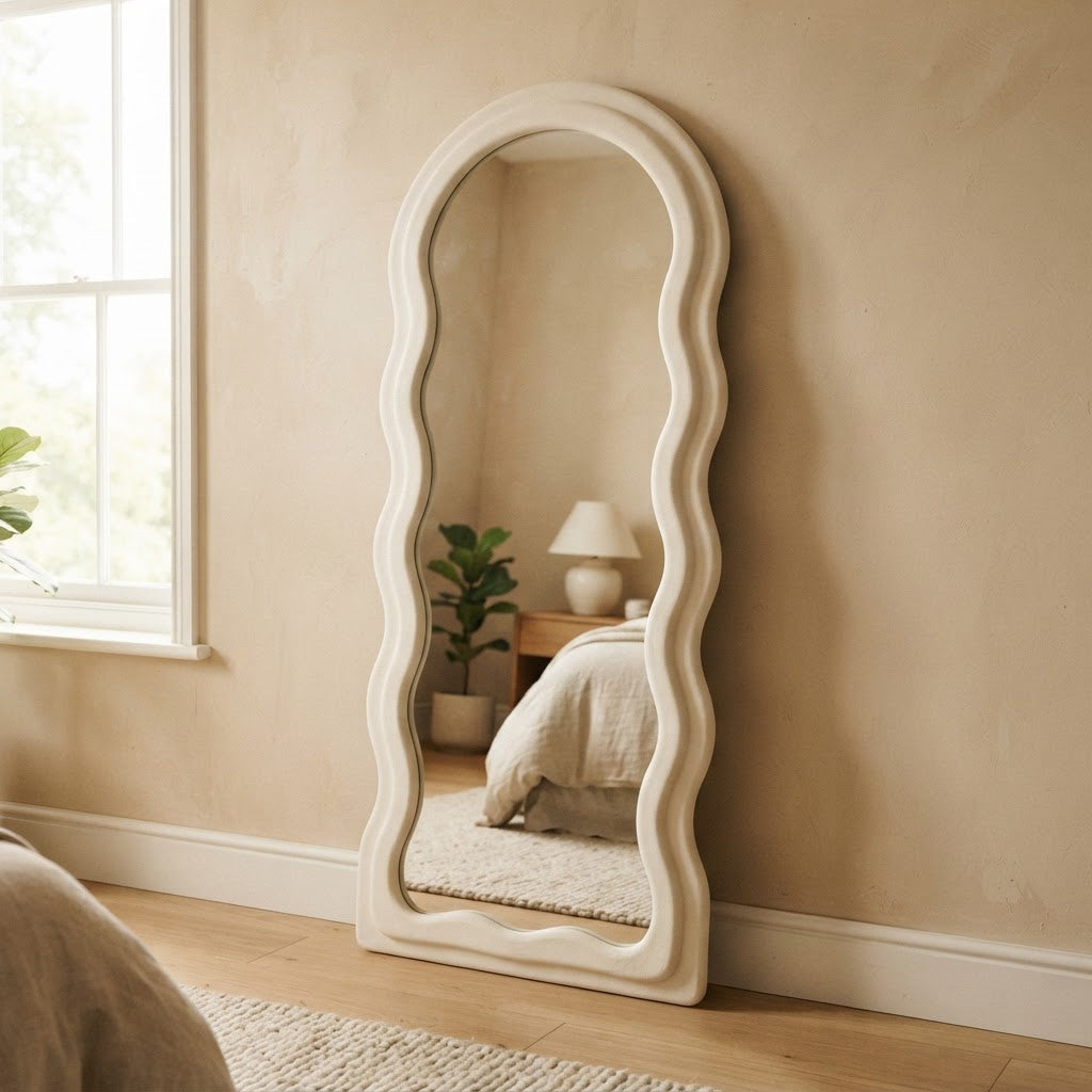 Cream 3D wavy arched full-length mirror leaning in a bedroom